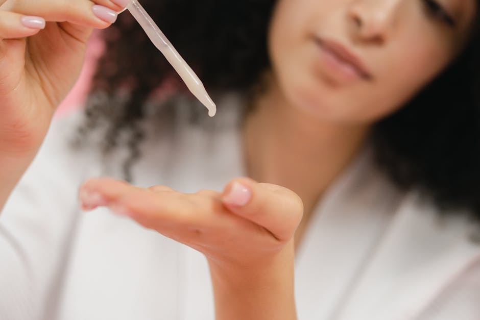 Close-up of a woman applying skincare serum with a pipette, focusing on body care and cosmetic application